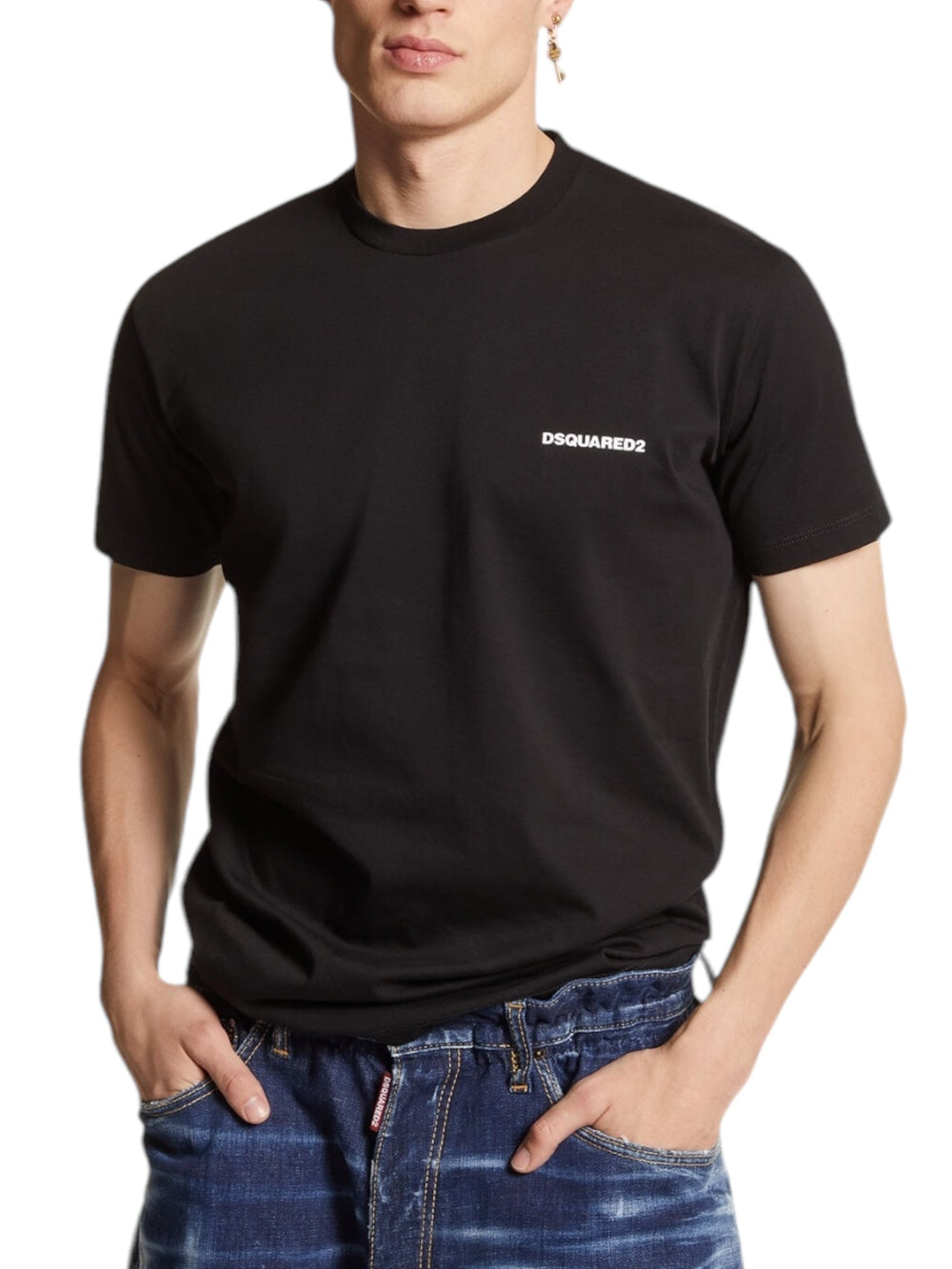 Wearing the Dsquared2 S74Gd1338 Cool Fit Tee Black from DSQUARED2, the person exudes an effortless vibe in men's fashion. The sleek black top paired with classic blue jeans and hands casually tucked in pockets completes the laid-back yet stylish look.