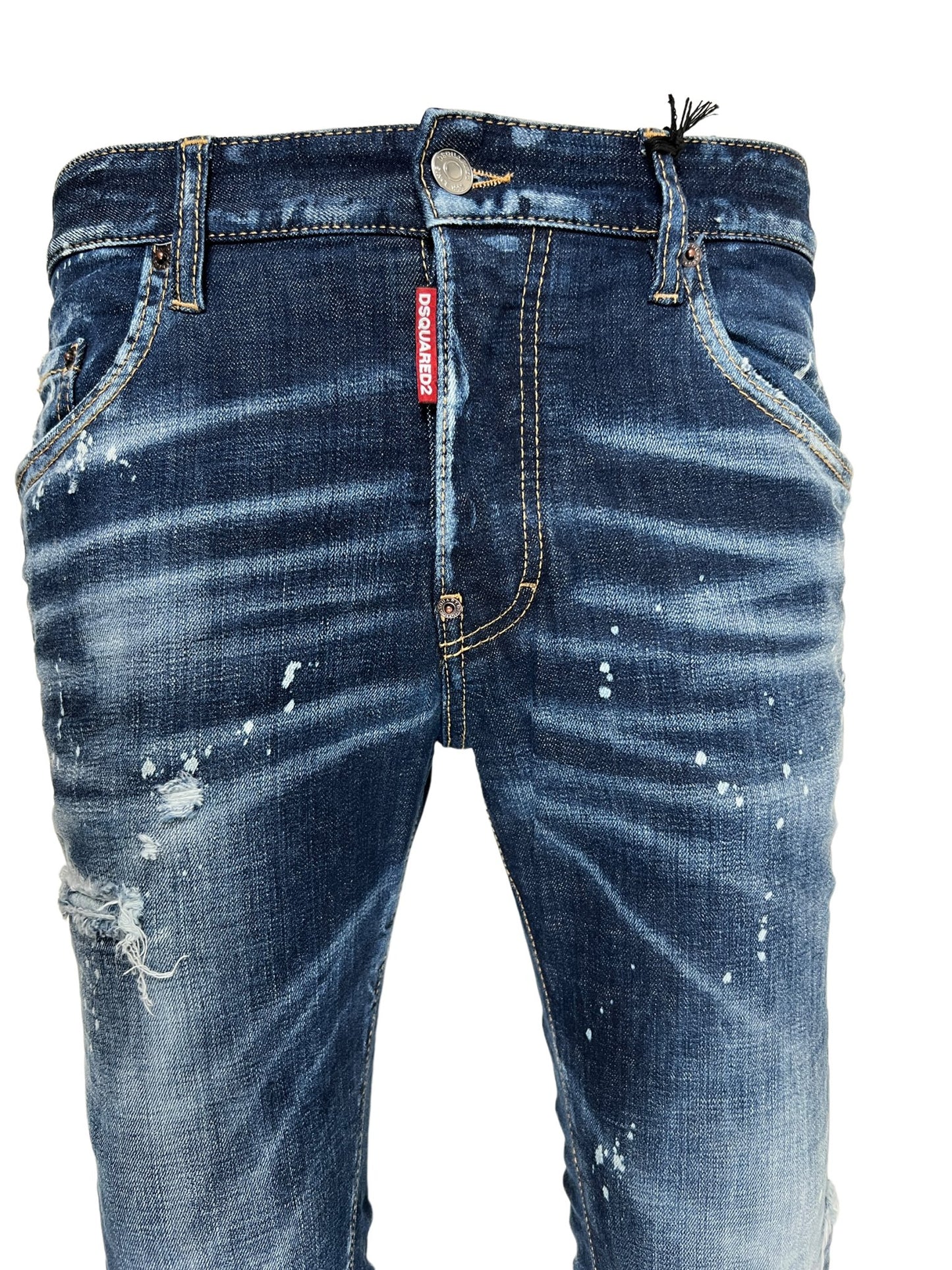 Close-up of distressed blue jeans with trendy ripped detailing and white paint splatters, visible stitching, and a red brand tag near the front pocket. These stylish slim fit DSQUARED2 S74LB1556 SKATER JEANS NAVY BLUE offer a modern, edgy look.