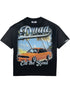 The DUAA Duaa Destination Blk Tee Shirt features "Duaa" and "On the Road" text with an orange sports car, palm trees, and a beach graphic—perfect for adding summer vibes to your casual style.