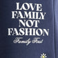 The FAMILY FIRST JOSS2503 Short Flower Dark Blue features navy cotton fabric, white "LOVE FAMILY NOT FASHION Family First" text, and a small embroidered white and yellow daisy at the bottom.