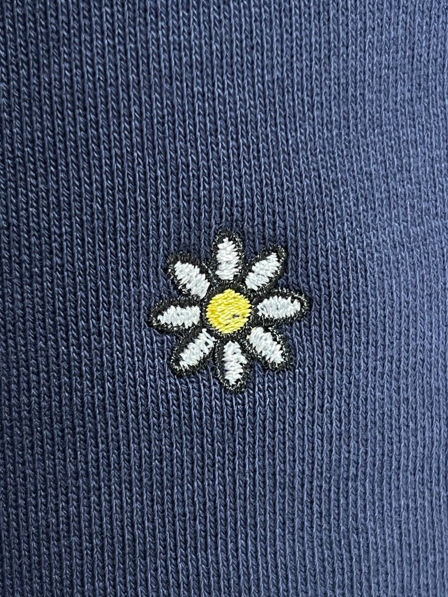 The Family First JOSS2503 Short Flower Dark Blue by FAMILY FIRST features a charming small embroidered white daisy with a yellow center on soft cotton navy blue shorts.