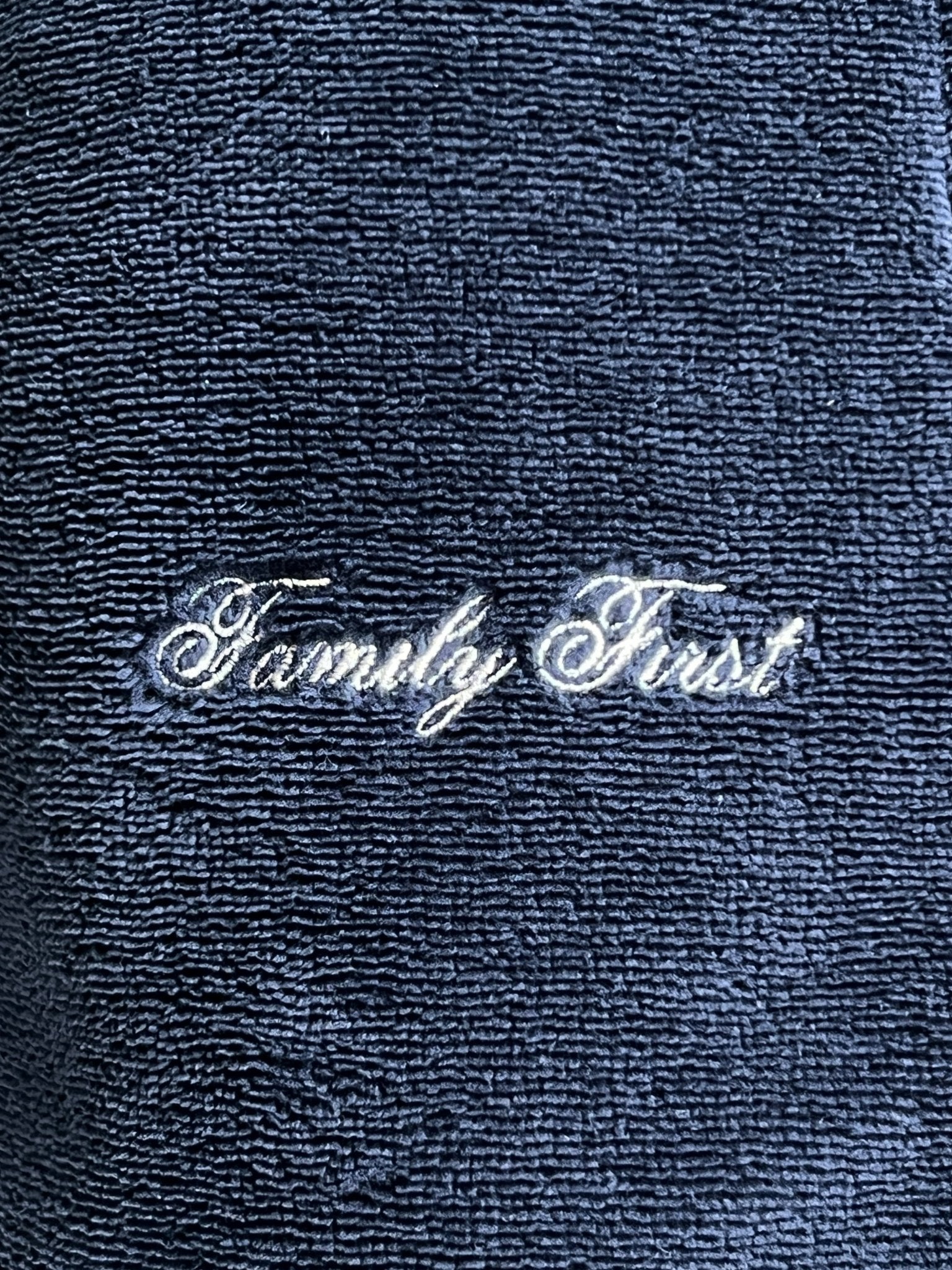 Close-up of the dark blue Family First JOSS2504 Jogger Short Track fabric with "Family First" embroidered in white cursive, ideal for jogging attire.