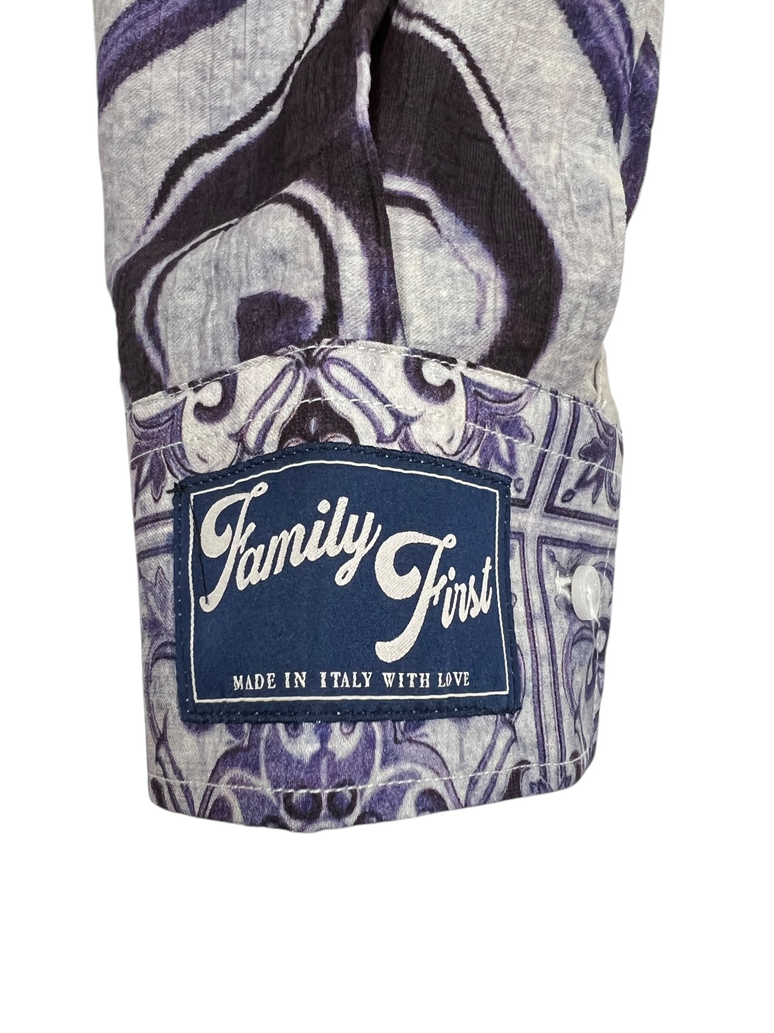 Close-up of a Family First SHS2504 Shirt Amalfi Multicolor cuff showing a blue and white tag reading "Made in Italy with Love." The ramie fabric displays a multicolor ornate pattern with gray and purple.