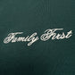The Family First TF2409GR T-shirt in green features luxurious fabric adorned with "Family First," elegantly embroidered in white cursive lettering.