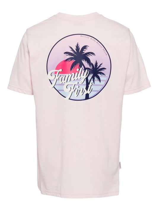 Back view of a light pink 100% cotton FAMILY FIRST t-shirt with a tropical-themed graphic featuring palm trees and the text "family trip" in a circular design.