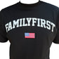 The Family First TS2416 T-Shirt College Black by FAMILY FIRST is made from 100% cotton and showcases "FAMILYFIRST" prominently in white, accompanied by a small American flag patch beneath.