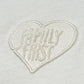 The Family First TS2504 T-shirt by FAMILY FIRST features heart tone white fabric with an embroidered heart and "FAMILY FIRST" in raised white stitching, offering subtle elegance.