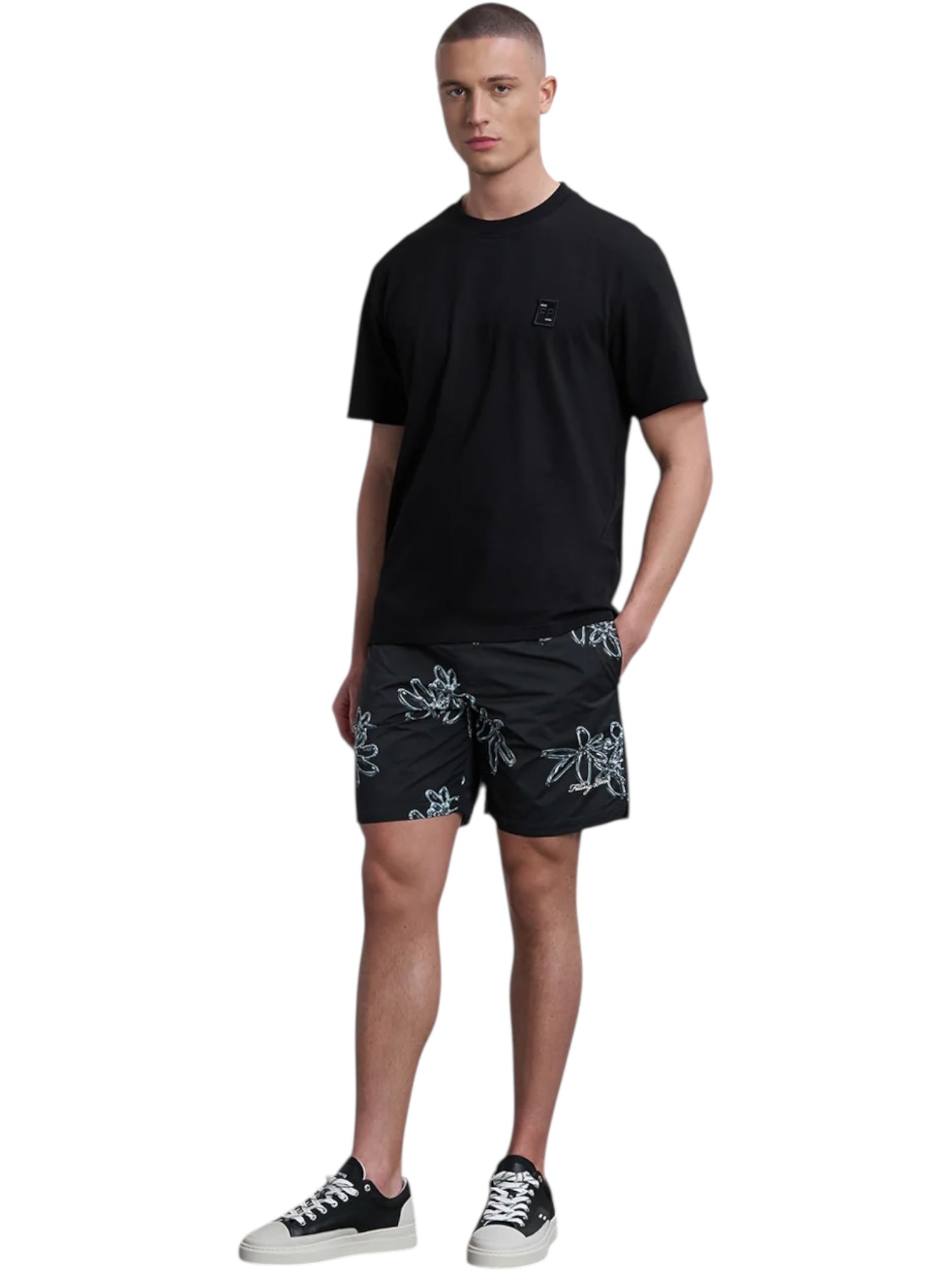 A person stands facing forward against a white background, wearing a black t-shirt, black-and-white sneakers, and FILLING PIECES Chrome Swimshorts Black.