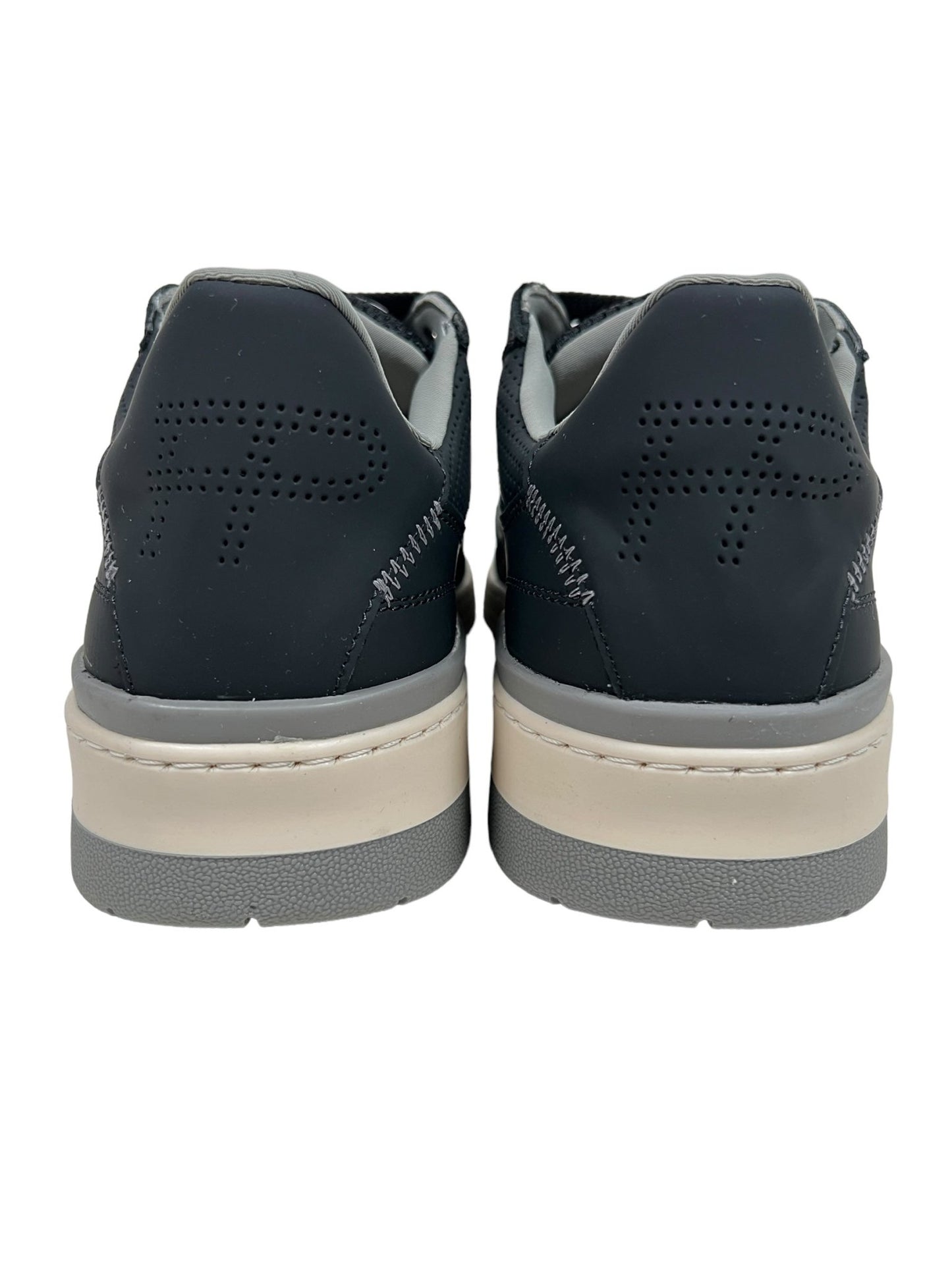 A rear view of the FILLING PIECES CRUISER BLACK sneakers made by FILLING PIECES, featuring dark-colored premium organic Nappa leather with a perforated design on the heel and light beige soles.