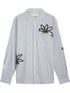 The FILLING PIECES Dress Shirt Flowers Antique White features blue vertical stripes and black abstract floral designs, blending modern style with subtle monogram detail for a distinctive look.