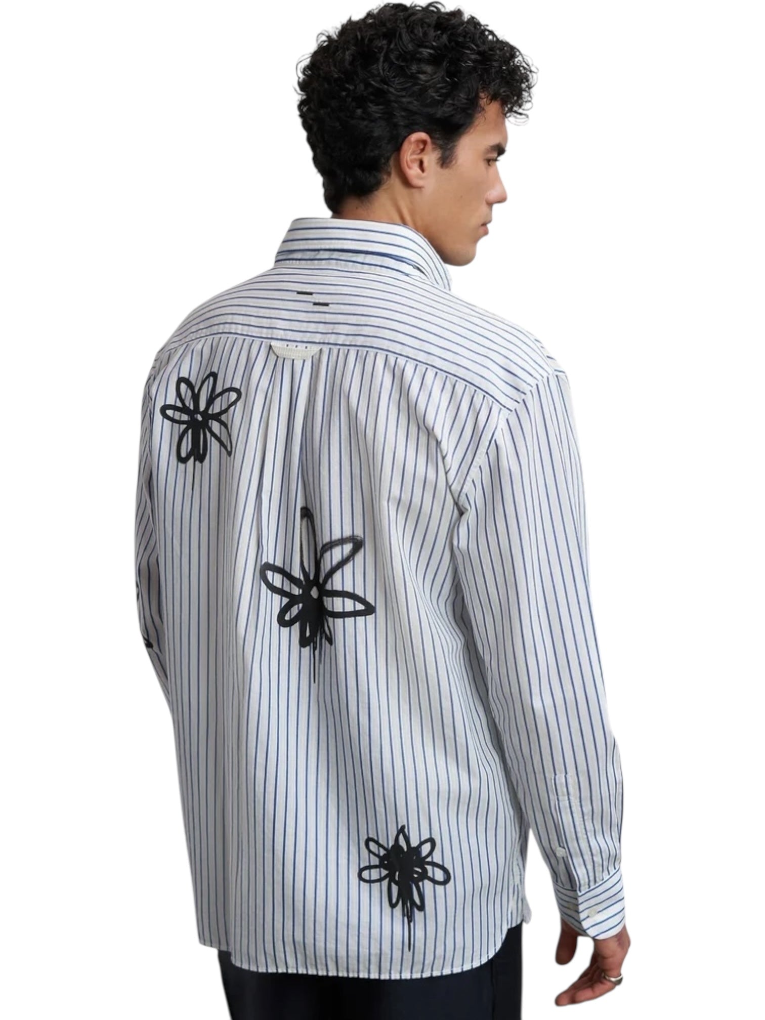 A man wears the Filling Pieces Dress Shirt Flowers Antique White by FILLING PIECES, featuring three black abstract floral monogram designs on the back, standing against a white background.