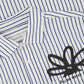 Close-up of the Filling Pieces Dress Shirt Flowers Antique White by FILLING PIECES, featuring blue vertical stripes, a black abstract floral monogram design, and branding on the label and chest.