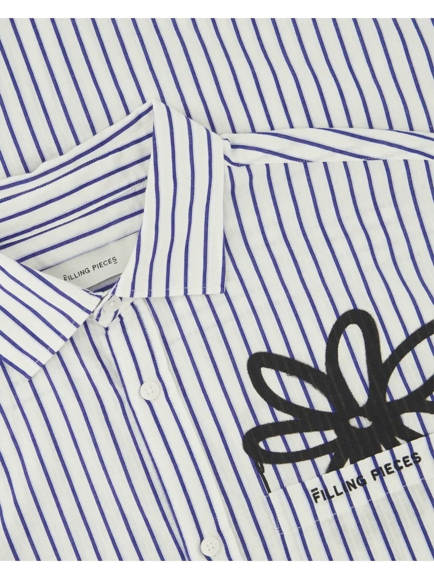 Close-up of the Filling Pieces Dress Shirt Flowers Antique White by FILLING PIECES, featuring blue vertical stripes, a black abstract floral monogram design, and branding on the label and chest.