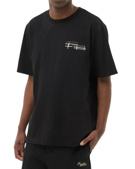 A person wearing the FILLING PIECES HANDSHAKE ELEMENTS BLK T-SHIRT made from 100% organic cotton, featuring a small handshake elements design on the chest, paired with matching black pants.