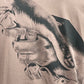 Close-up of an illustration on the FILLING PIECES HANDSHAKE FOSSIL T-SHIRT depicting two hands clasped together, suggestive of unity or support.