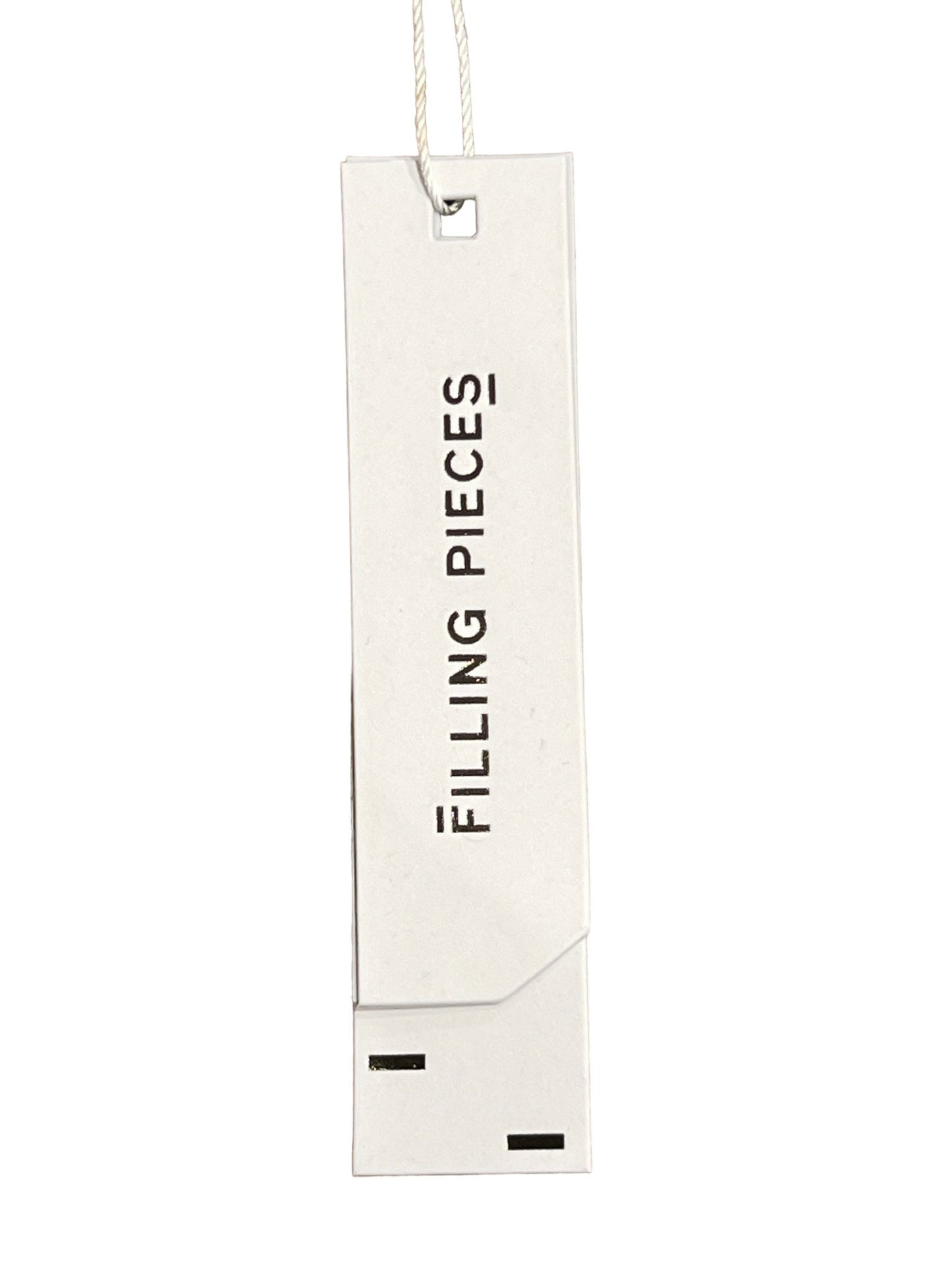 Clothing tag with text "FILLING PIECES RESORT MONOGRAM SHIRT MILK" on an organic cotton short sleeve shirt against a white background by FILLING PIECES.