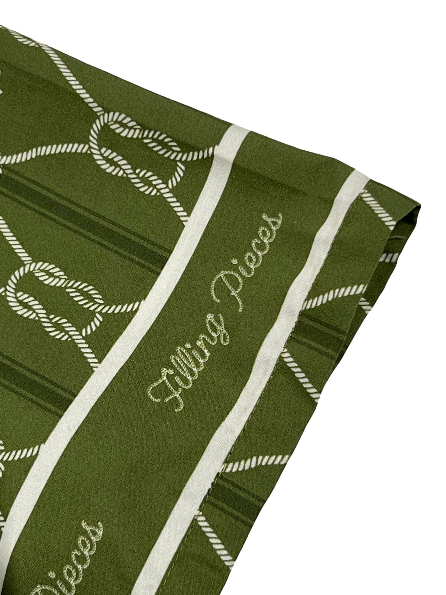 Green striped holiday-themed towel with candy cane motifs and FILLING PIECES RESORT MONOGRAM SHIRT OLIVE text embroidery by FILLING PIECES.