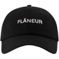 The FLANEUR Flaneur Logo Cap Black is a minimalist cotton cap with "FLÂNEUR" boldly embroidered in white on the front.