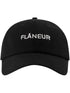 The FLANEUR Flaneur Logo Cap Black is a minimalist cotton cap with "FLÂNEUR" boldly embroidered in white on the front.