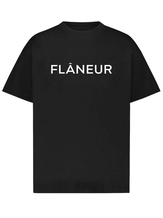 A stylish T-shirt from FLANEUR, known as the FLANEUR PRINTED LOGO T-SHIRT BLACK, showcasing the word "FLÂNEUR" prominently in white capital letters across the chest.