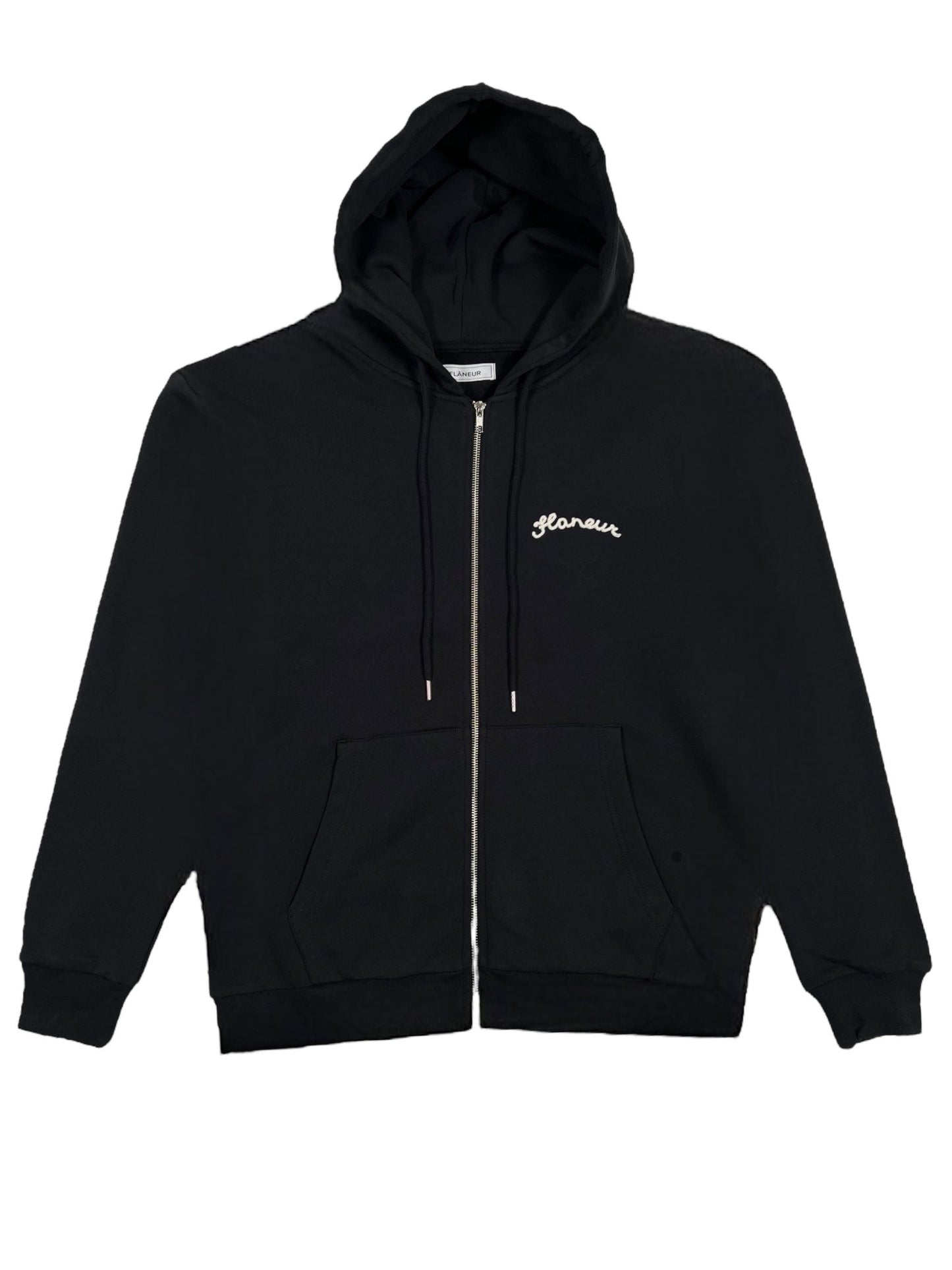 The FLANEUR SIGNATURE ZIP-UP HOODIE BLACK by FLANEUR is a black hoodie made from 100% cotton, featuring a front pocket and "Hawaii" embroidered in white on the left chest.