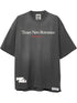 The FREE REFILLS Free Refills Romance Tee (FR-C3-12) in vintage black is an oversized heavyweight cotton t-shirt with a faded wash, "Times New Romance" in white, "FREE refILLS" in red, and label details by the hem.