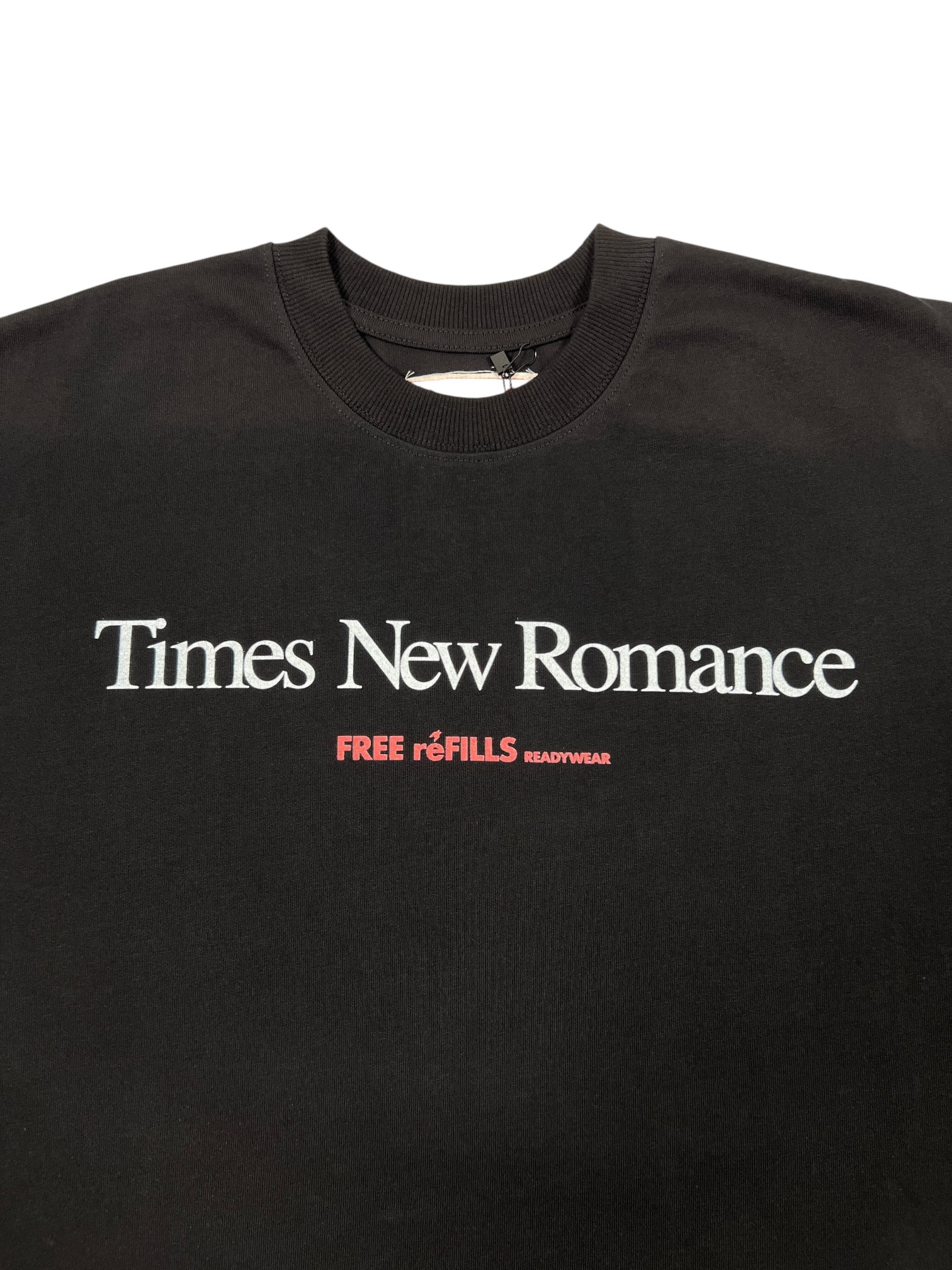 The FREE REFILLS Free Refills Romance Tee (FR-C3-12) is a vintage black heavyweight cotton T-shirt featuring "Times New Romance" in bold white and "FREE FILLS READYWEAR" in red; true to size fit.