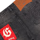 Close-up of the back of GODSPEED OG Logo Flared Denim Grey Wash, featuring a brown leather patch, embroidered pockets, and a red "G" Godspeed label. Crafted from 100% cotton.