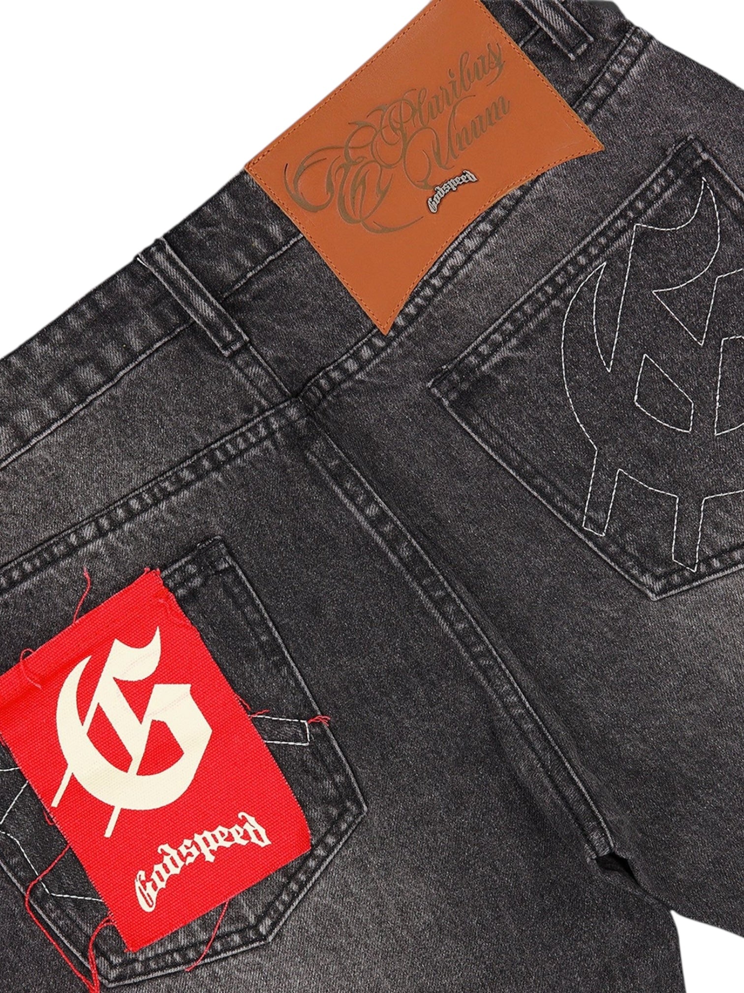 Close-up of the back of GODSPEED OG Logo Flared Denim Grey Wash, featuring a brown leather patch, embroidered pockets, and a red "G" Godspeed label. Crafted from 100% cotton.
