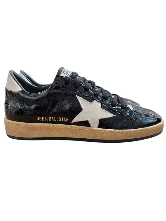 Golden Goose GMF00117 Ball Star Black/Latte sneakers, by GOLDEN GOOSE, feature a black design with a white star and beige sole. "GGDB/BALLSTAR" text adorns the side, while Italian craftsmanship and a distressed finish bring urban chic to any look.