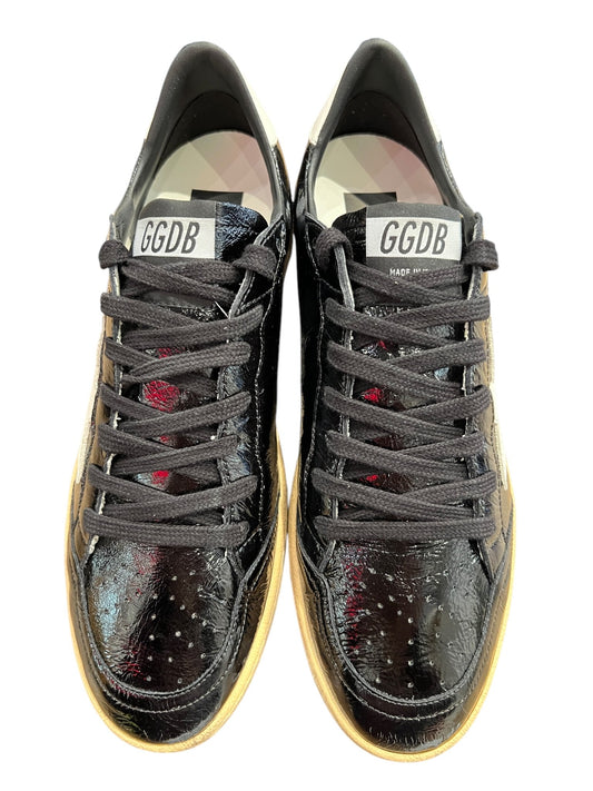 The Golden Goose GMF00117 Ball Star sneakers showcase Italian craftsmanship with a shiny black exterior, "GGDB" on the tongue, black laces, light brown soles, and a distressed finish for edgy elegance.