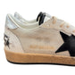 Golden Goose GMF00117 sneakers in white and beige feature black leather stars, textured sides, and worn brown rubber soles.