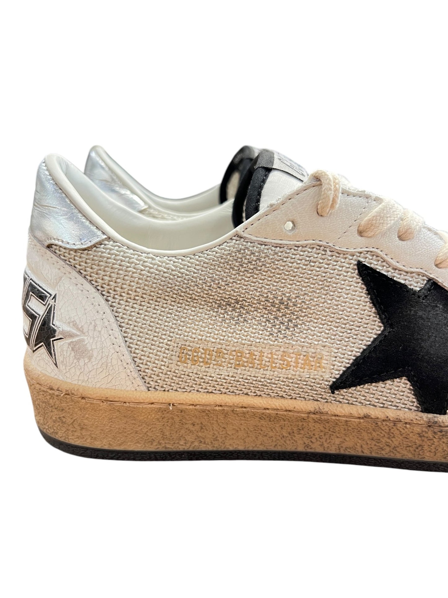 Golden Goose GMF00117 sneakers in white and beige feature black leather stars, textured sides, and worn brown rubber soles.