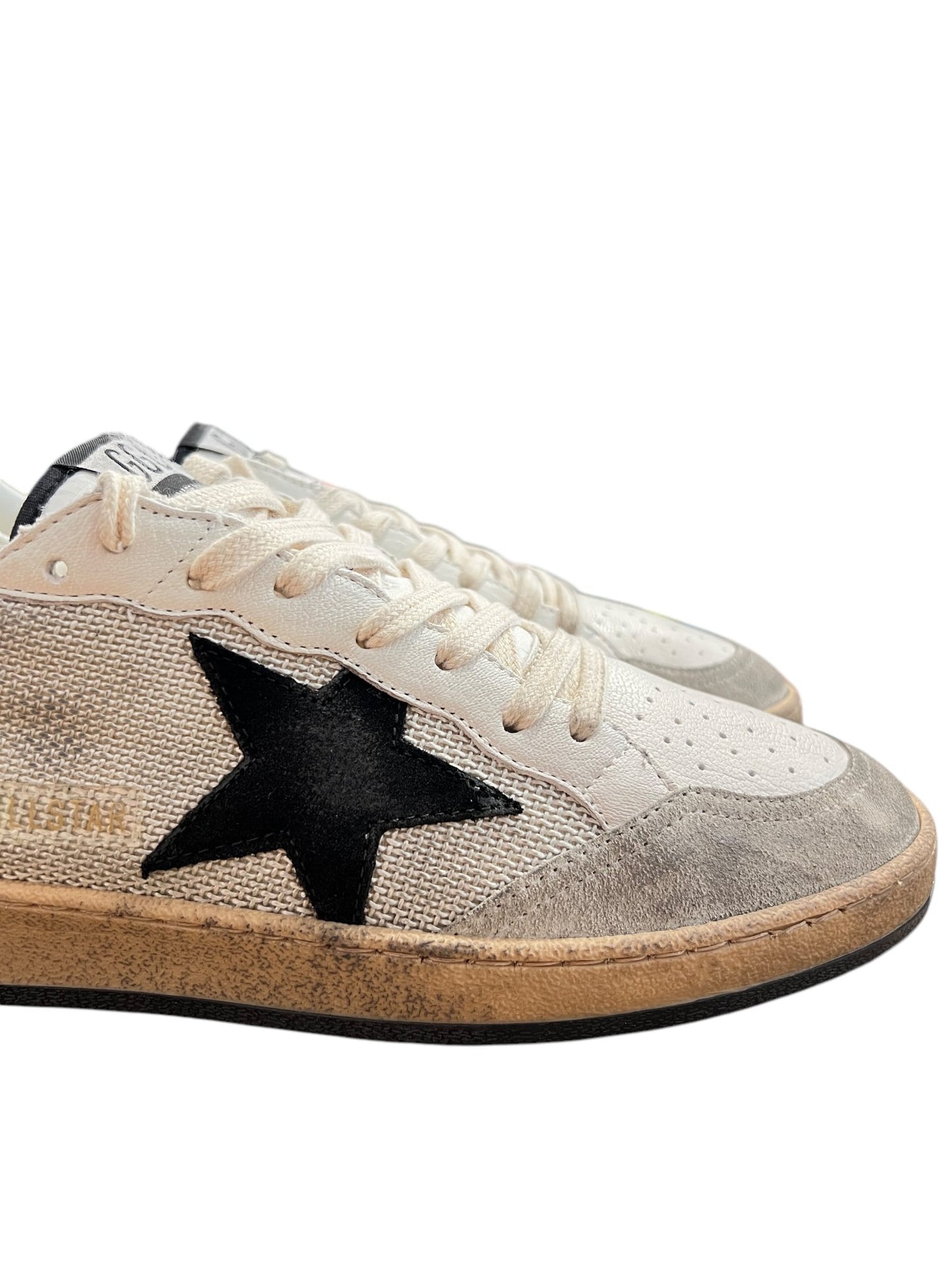 The Golden Goose GMF00117 Ball Star sneakers feature a black leather star design on white and beige with textured sides and slightly worn rubber soles, by GOLDEN GOOSE.