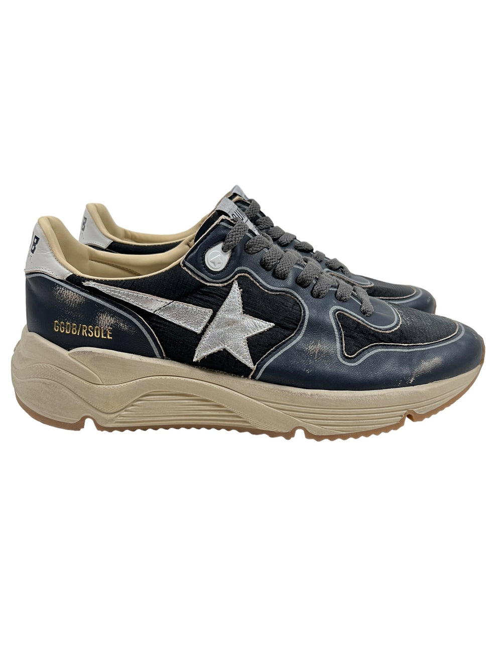 A pair of dark blue, black, silver, and white athletic shoes with a white star logo, beige soles, and gold text on the side reading "GGBD/RSOLE." These sleek GOLDEN GOOSE GMF00126 RUNNING SOLE DK BLU/BLACK/SLV/WHT sneakers feature the signature Running Sole for added comfort.