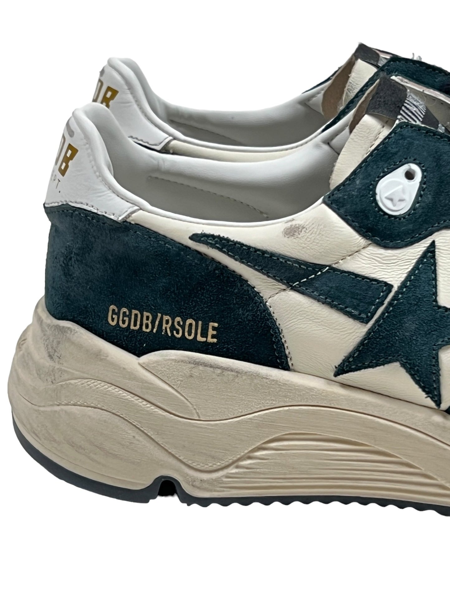 Close-up of a pair of GOLDEN GOOSE GMF00126 RUNNING SOLE sneakers, featuring a black star detail on white leather with "GGDB/RSOLE" text on the heel. The shoes have a slightly dirty off-white sole.