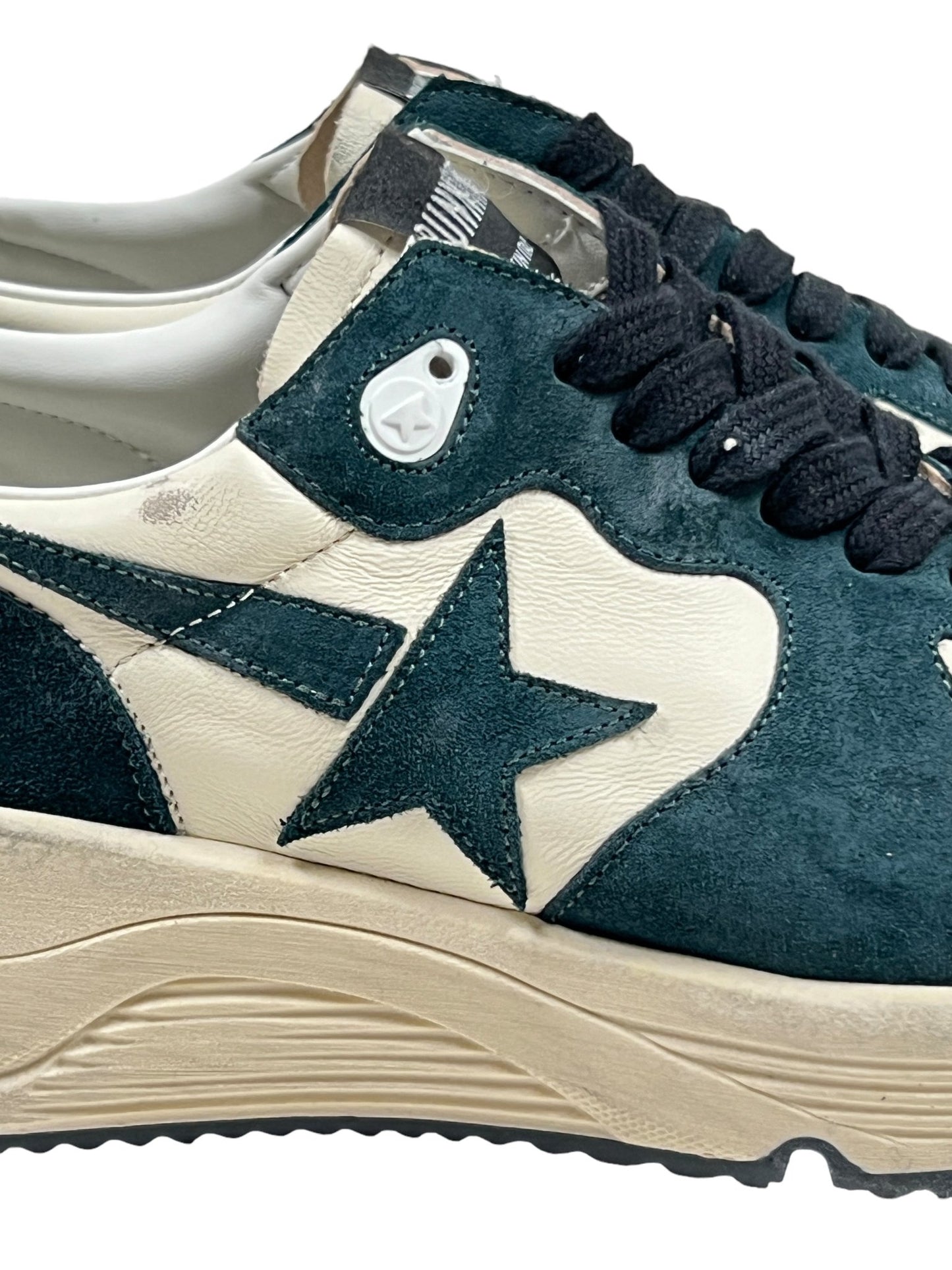 Close-up of the GOLDEN GOOSE GMF00126 RUNNING SOLE SUEDE DK GREEN/WHITE sneakers featuring star-shaped cutouts, black laces, and a beige running sole.