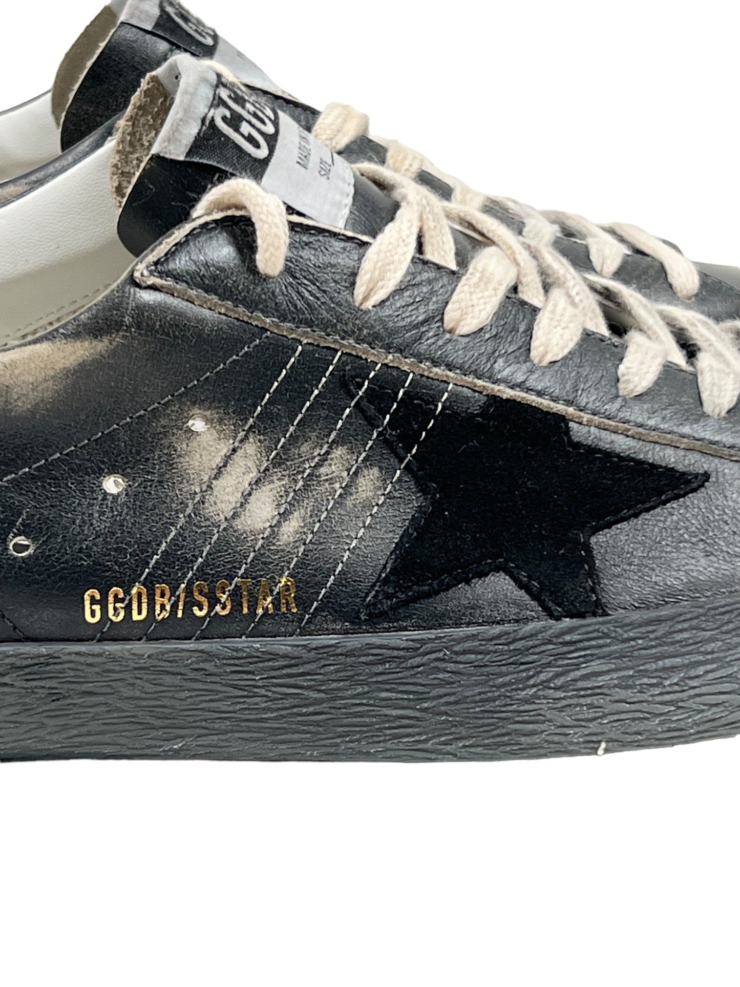 Close-up image of the GOLDEN GOOSE GMF00290 SUPER STAR LEATHER BLACK SILVER sneaker, featuring black silver leather, a star emblem, white laces, and "GGBDSTAR" branding on the side.