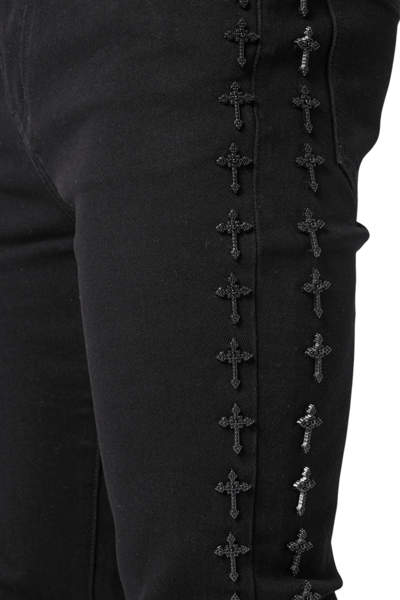 GUAPI's Guapi All Black Crosses Embellished Denim offers a modern slim tapered fit with streetwear aesthetics, featuring small embroidered crosses along the side seam.