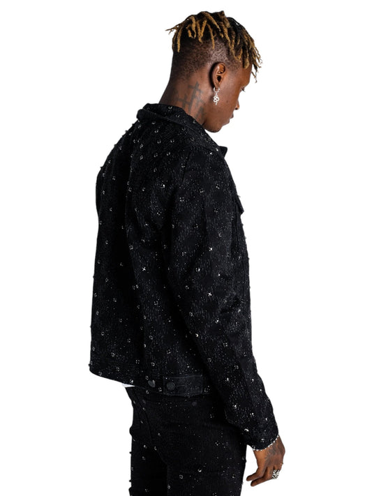 An individual is wearing a Guapi All Black Embellished Denim Jacket Blk by GUAPI, positioned sideways against a white background.