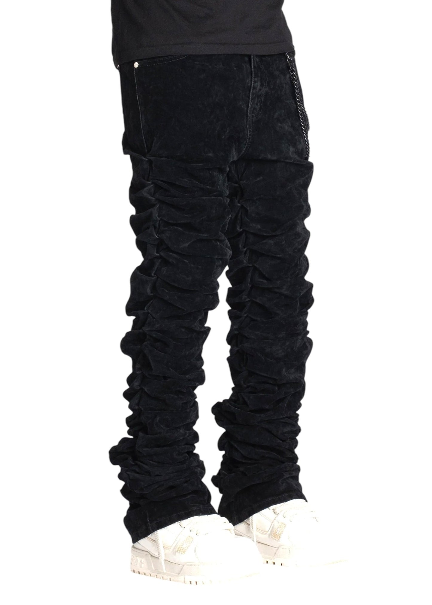 An individual is dressed in GUAPI's All Black Super Stacked Denim V2, paired with white sneakers, visible from waist to feet against a plain background.