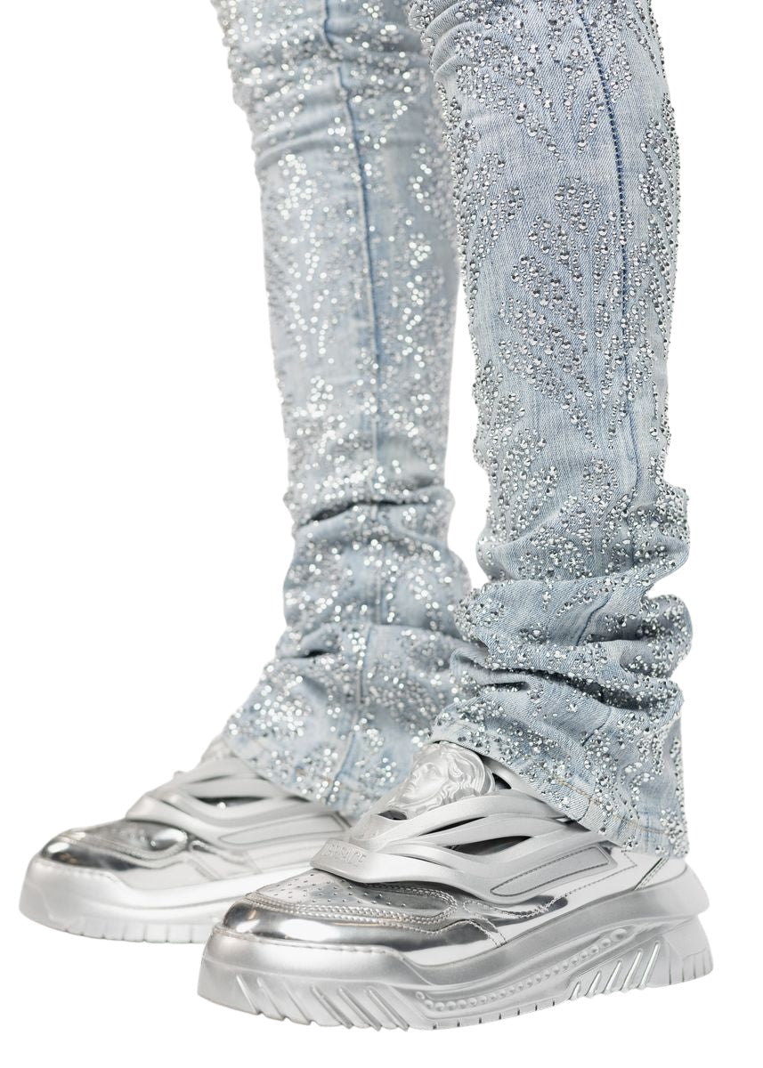 Close-up of someone wearing GUAPI's Aqua Blue Embellished Denim V2 with metallic silver sneakers, capturing luxury fashion.