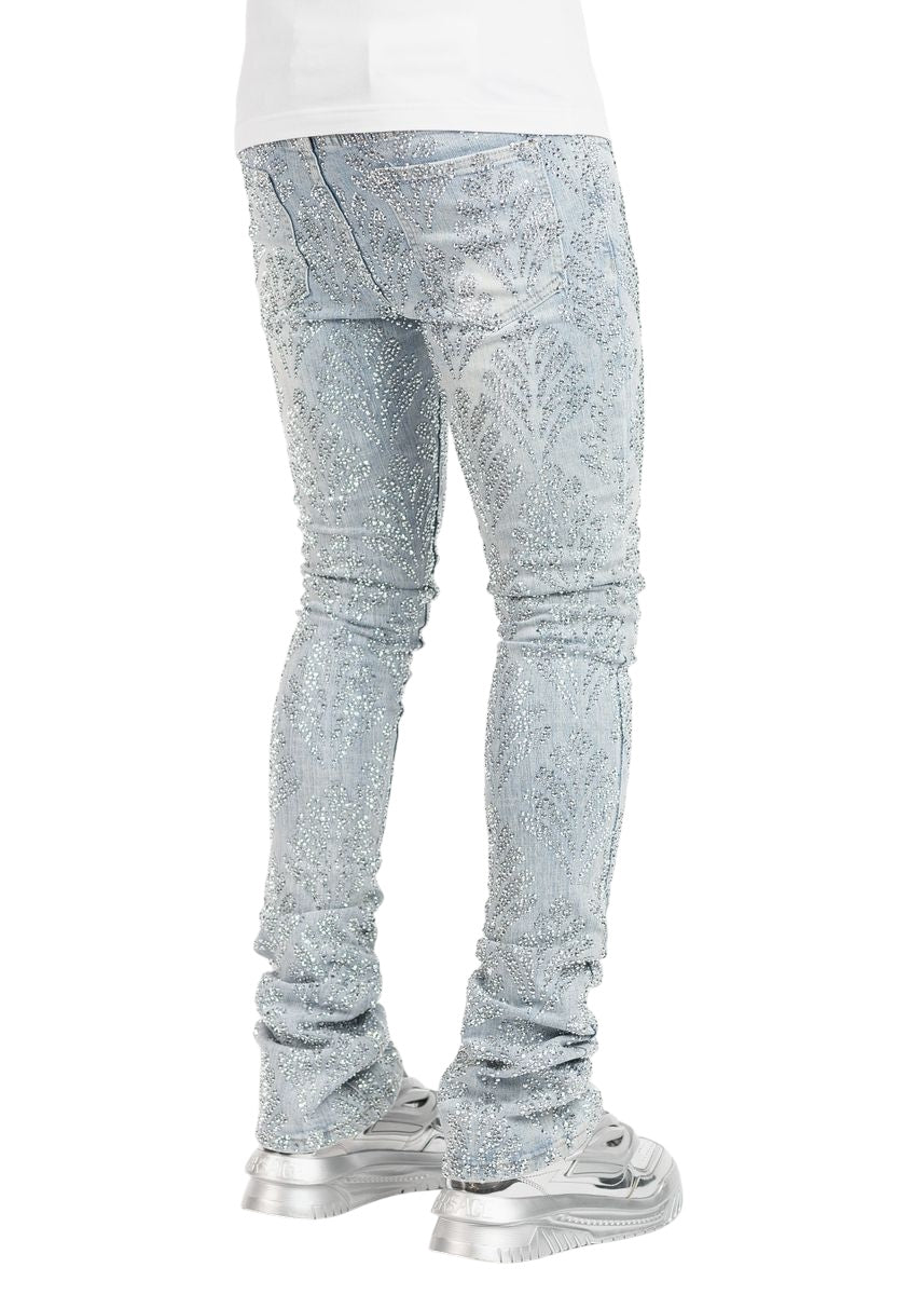 A person in GUAPI's Aqua Blue Embellished Denim V2 and silver sneakers stands with their back to the camera, highlighting a fusion of trendy denim and contemporary style.