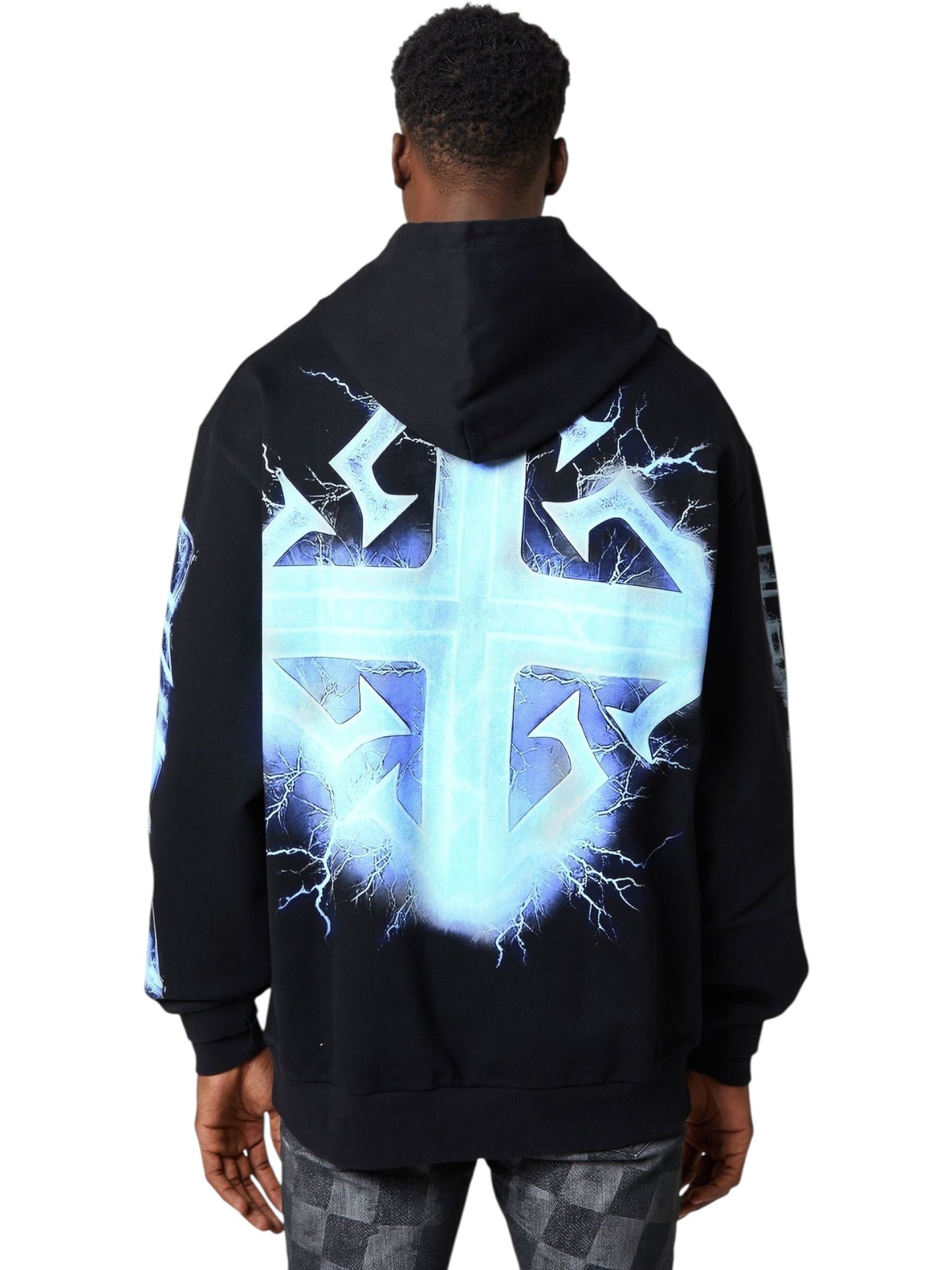 Someone wears the Guapi Black Revived Hoodie V2 by GUAPI, which features a large glowing blue cross with lightning effects on the back, standing against a plain background.