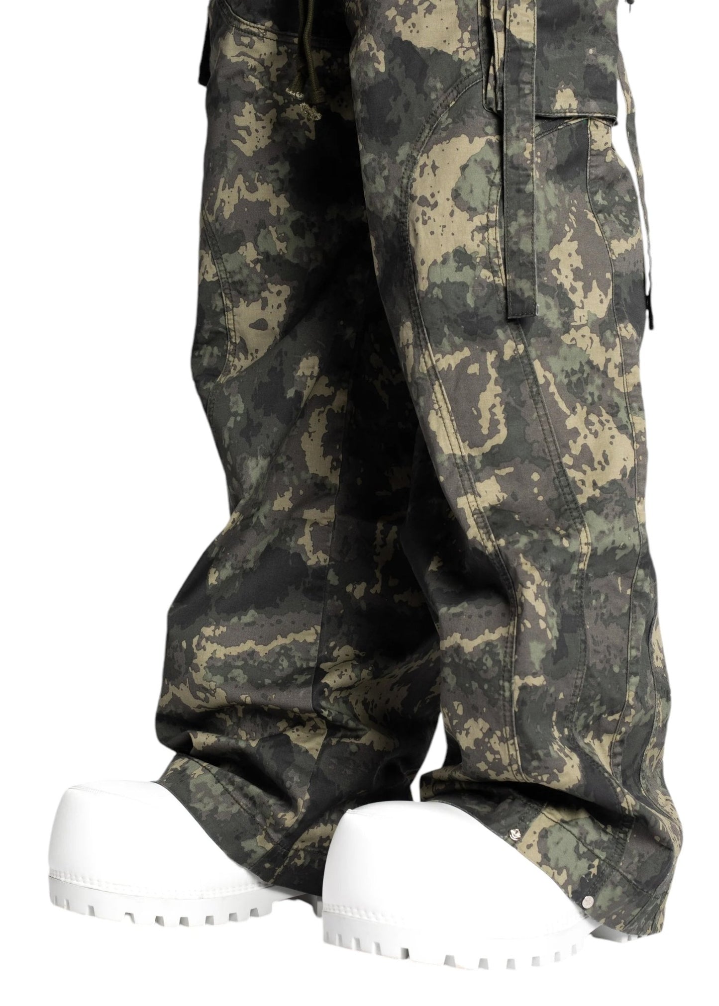 Person sporting a streetwear vibe with Guapi Camo Extra Baggy Cargos V3 by GUAPI and oversized white boots.