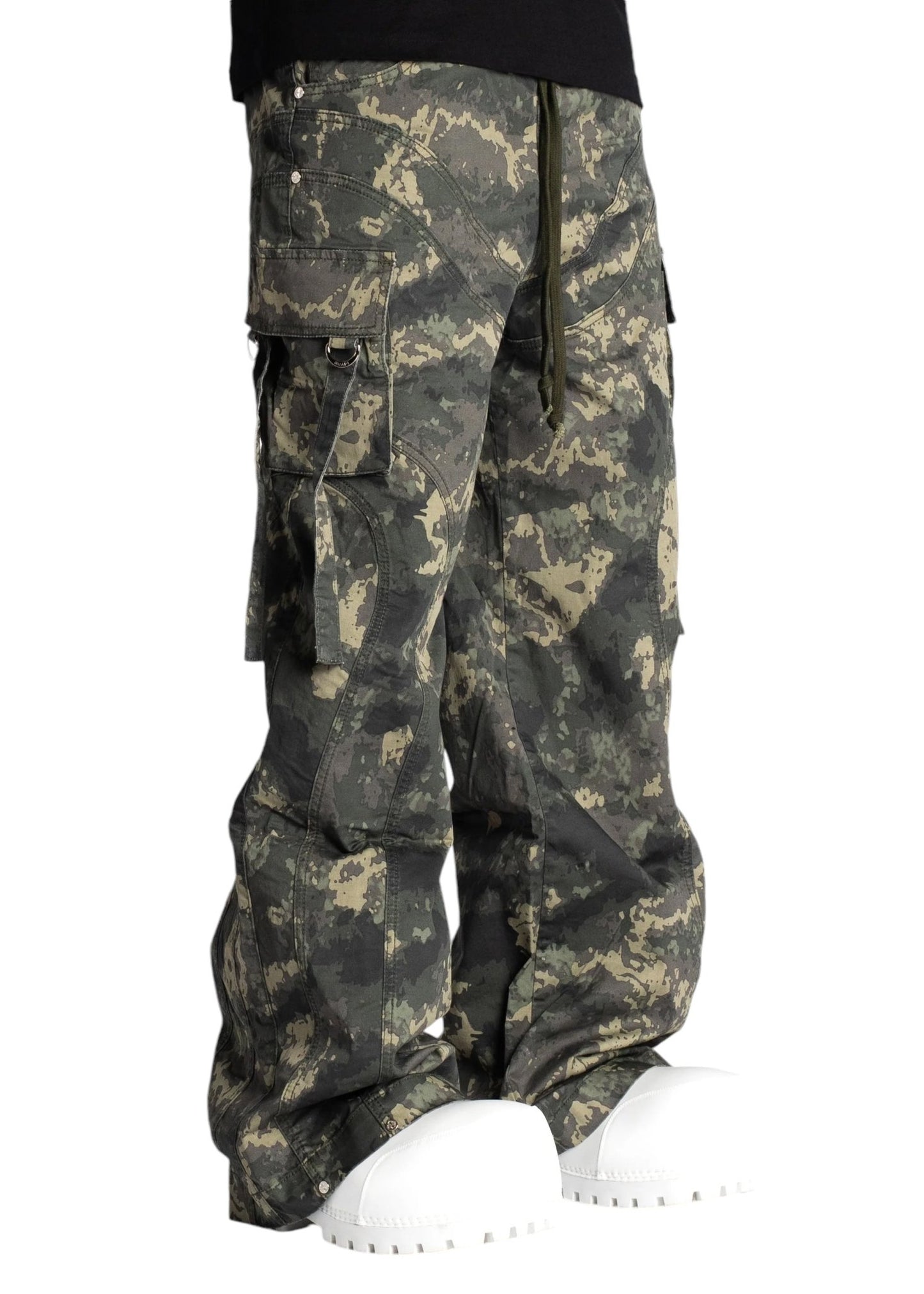 A person showcasing streetwear with GUAPI's Guapi Camo Extra Baggy Cargos V3 and oversized white shoes against a plain background.