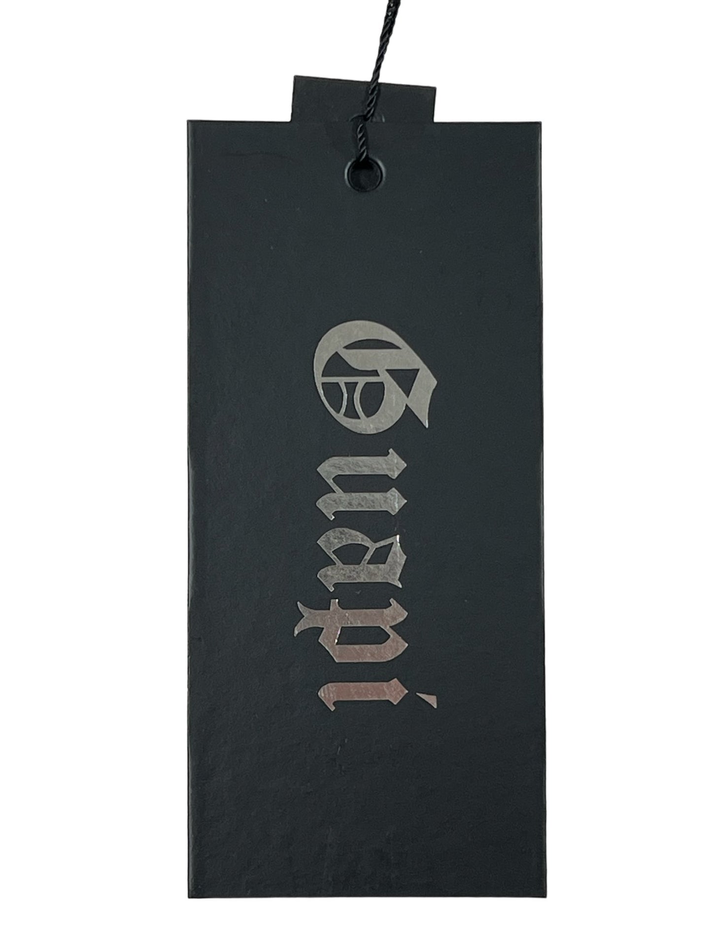 Black GUAPI luxury denim price tag with cut-out logo and text design hanging by a string.