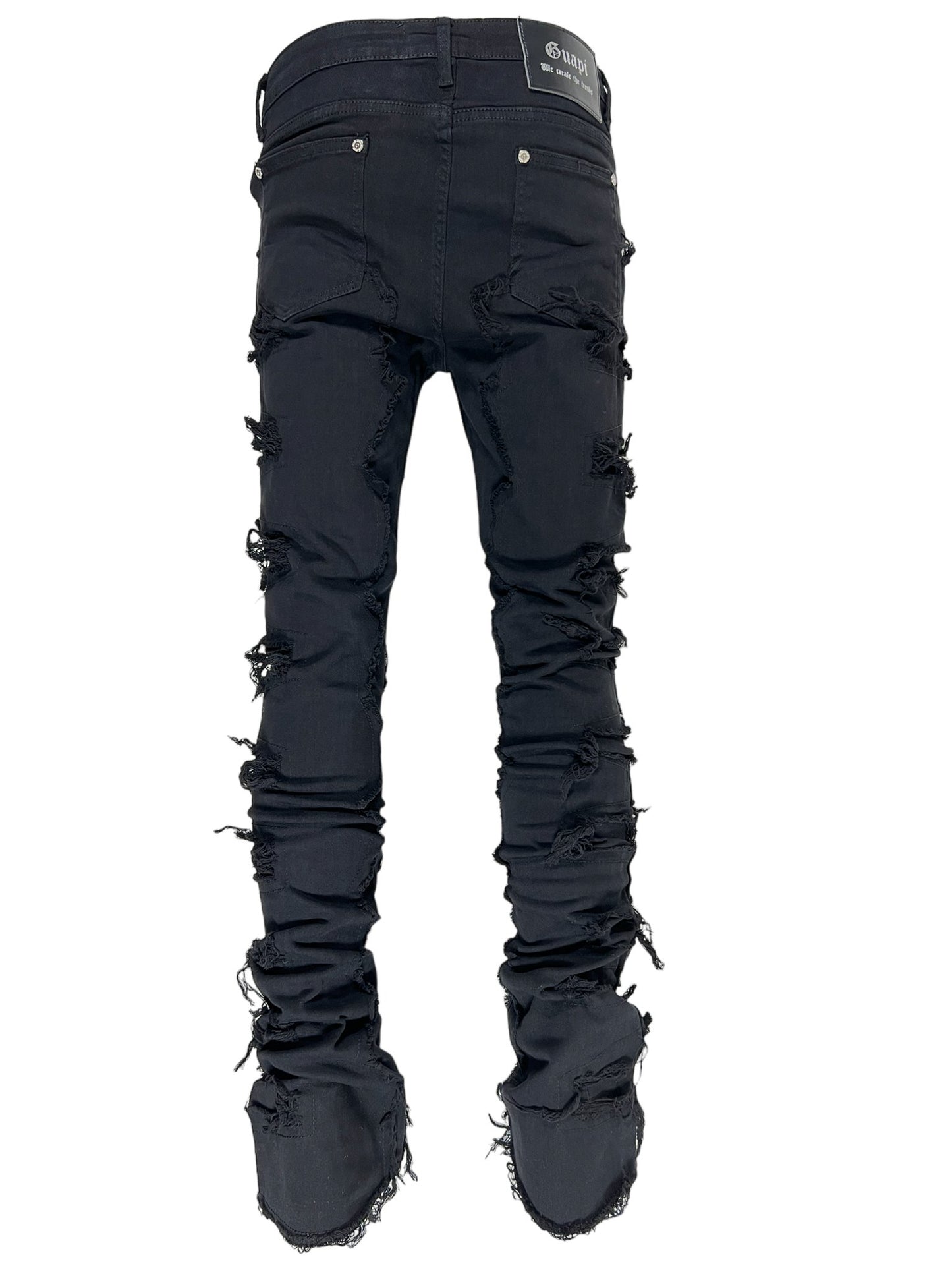 A pair of GUAPI OBSIDIAN BLACK BLOOD DIAMOND STACKED DENIM jeans with multiple rips and frayed edges, displayed against a white background.