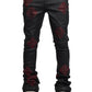 A person wearing GUAPI's Guapi Obsidian Black Icon Embellished Denim V2 with red geometric patterns and white sneakers, showcasing iconic detailing for added flair.