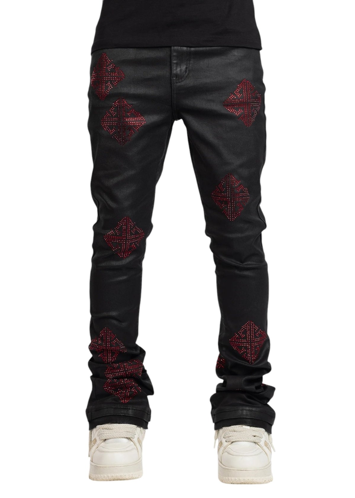 A person wearing GUAPI's Guapi Obsidian Black Icon Embellished Denim V2 with red geometric patterns and white sneakers, showcasing iconic detailing for added flair.